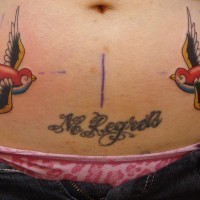 Le tatouage de ventre avec deux hirondelles avec une inscription sans regret