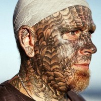 Spider webs tattooed on face