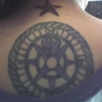 el tatuaje grande de una aguja de marear con una estrella nautica hecho en la espalda