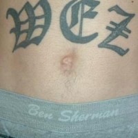 Stomach tattoo, three big letters, styled  inscription