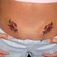 Bauch Tattoo von zwei gleichen geschmückten mit Schnörkeln Schmetterlingen