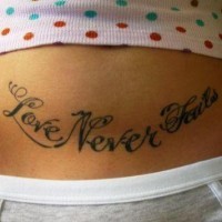 Stomach tattoo, love never fails, styled inscription