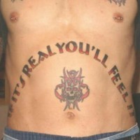 Le tatouage de l'estomac avec une crâne rouge avec une inscription
