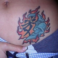 Bauch Tattoo mit grinsendem Mond im Flammen und Hieroglyphe