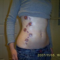 Stomach tattoo, beautiful red flowers, curly plant
