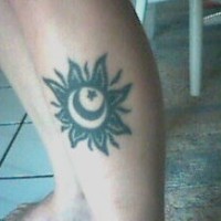 Black ink sun and moon tattoo on leg