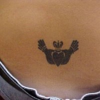 Claddagh ring symbol tattoo on lower back