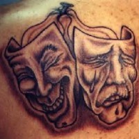 Theatrical masks black ink tattoo