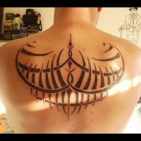 Tatuaggio sulla schiena il disegno in stile tribale in formi degli ali