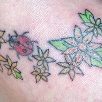 Le tatouage de coccinelle sur les fleurs de champ en couleur
