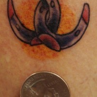 Tattoo of two tiny horseshoes