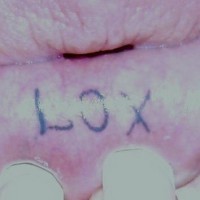 Tattoo on bottom lip, lox, short black word