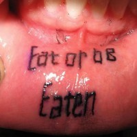 Tattoo on inside lip, eatorob eaten, two black words