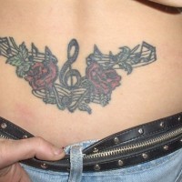 Tattoo on lower back, treble clef, notes, flowers