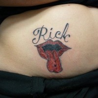 Tatuaje en vientre con labios y lengua de color rojo y una inscripción