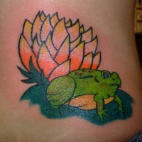 Green frog on upper back tattoo with lily