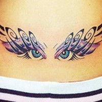 Tribal eyes lower back tattoo