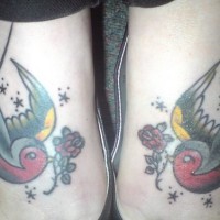 Le tatouage de deux joli moineaux avec des fleurs sur le pied