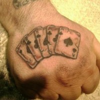 Cinque carte da gioco tatuate sulla mano