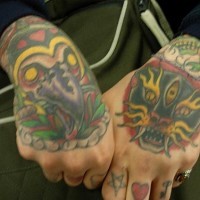 Disegni colorati in stile tribale tatuati sulle mani: gufo e tigre feroce