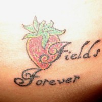 Les champs pour toujours tatouage sur la hanche avec une fraise rouge