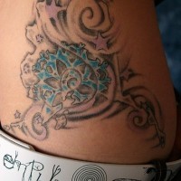 Stilisiertes Tattoo von Schnörkeln, Seepflanze, Sternen an der Hüfte