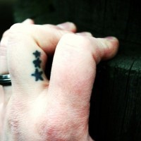 Tattoo von drei winzigen Sternen in Schwarz am Finger