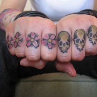 Tattoo mit vier schönen Blumen und Totenköpfen an Fingerknöcheln