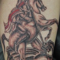 Le tatouage sur le mollet d'un guerrier sur le cheval tuant un autre guerrier