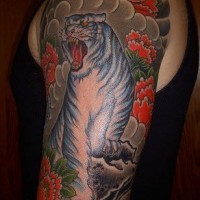 Brillante tatuaje del tigre de nieve rodeado de flores