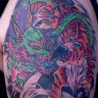 Batalla entre tigre y dragón verde tatuaje en el hombro