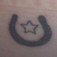Tiny black horseshoe with star tattoo