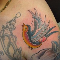 Pequeño tatuaje de golondrina en color