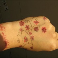 Tree hand tattoo with red flowers