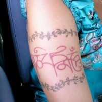 Tatuaggio colorato intorno del braccio la scritta in arabo