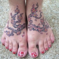 Tattoo mit Baum und bunten Blumen an Füßen