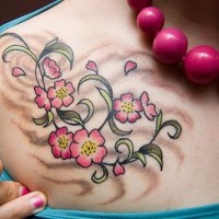el tatuaje femenino con una traceria floral de color