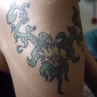 el tatuaje en colores palidos con una flor y las hojas hecho en el hombro