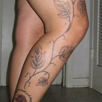 el tatuaje de una rama con hojas hecho en la pierna