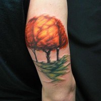Buntes Tattoo am Arm mit Bäumen