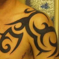 Tatuaje en brazo, hombro estilo tribal en tinta negra