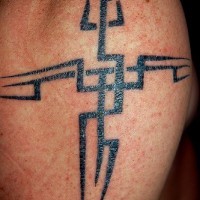 Tribal style cross tattoo on shoulder
