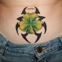 Green shamrock on tribal tattoo