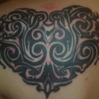 Tatuaje en la espalda el corazón estilo tribal en negro