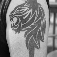 El tatuaje tribal de la cabeza de un leon negro rugiendo