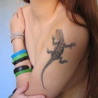 El tatuaje realista de una lagartija en el brazo o hombro