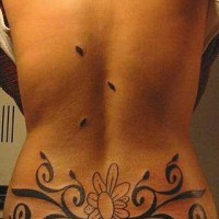 Tatuaje en bajo de la espalda flor estilo tribal con muchos elementos