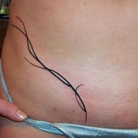Tribal lower belly tattoo with long thin lines