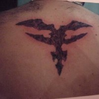 Tatuaje estilo tribal en tinta oscura en la espalda
