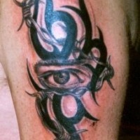 Tatuaje en tinta oscura el signo tribal con el ojo muy realístico